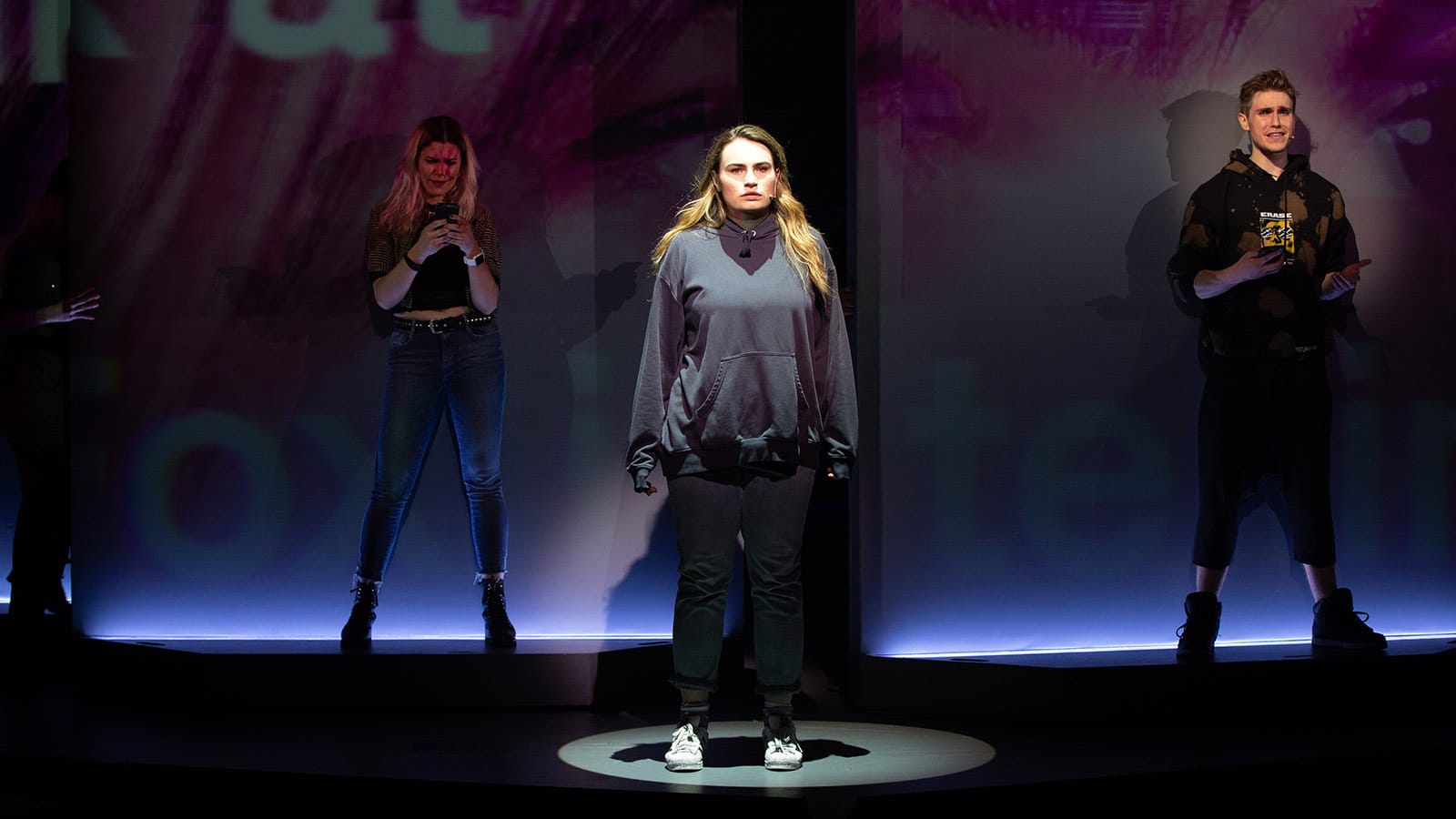 Kathryn Gallagher as Bella (center) and members of The Chorus, Jane Bruce and John Cardoza in American Repertory Theater's Jagged Little Pill